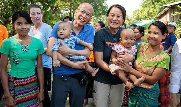 World Vision partners holding a child alongside their mothers.