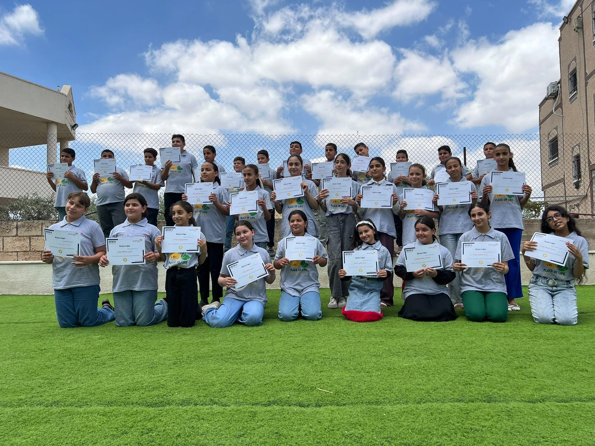 Children hold up certificates