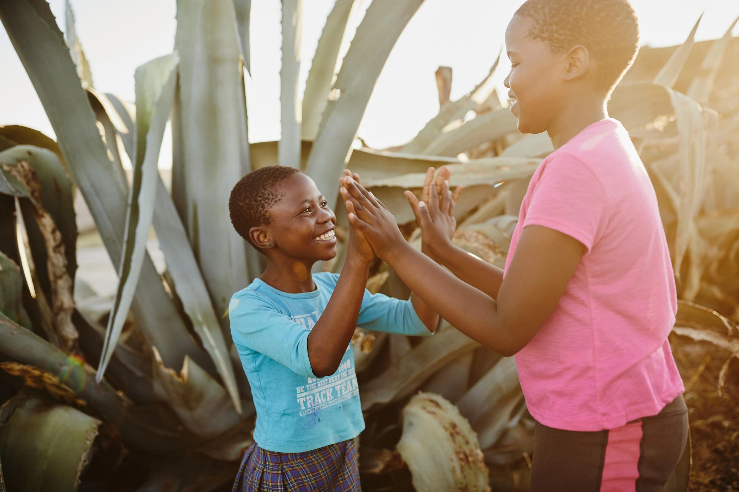 Children play together outdoors, smiling and enjoying each other's company.