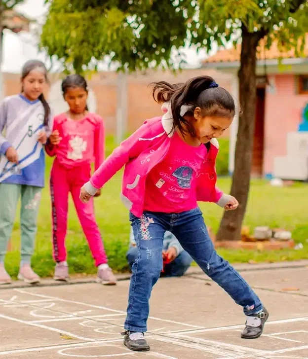 A girl plays hopscotch with her friends.