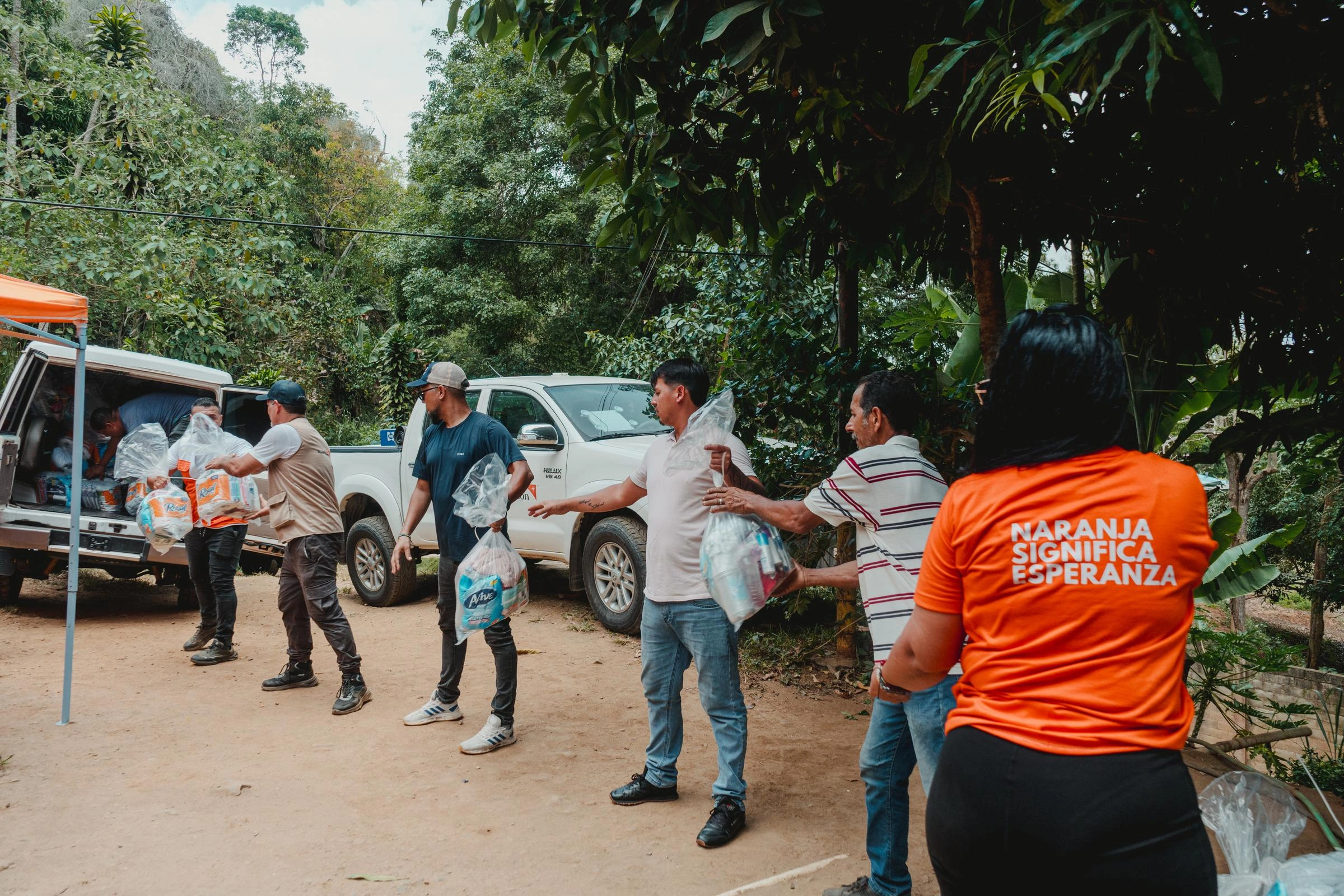 An assembly line of people distribute food kits.