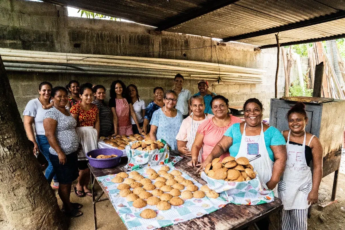Women in Honduras inside a bakery showing baked goods they made for Giving Season.