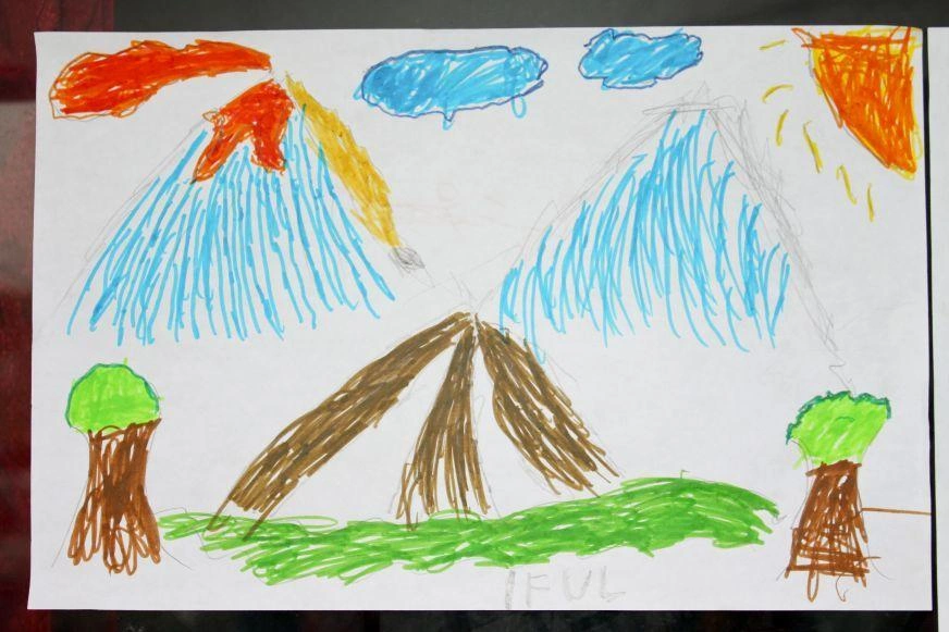 A child’s magic marker drawing does fire, lava and smoke emerging from a giant mountain.