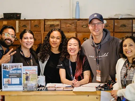 World Vision Canada staff welcome supporters at a donation registration table during a community fundraising event.