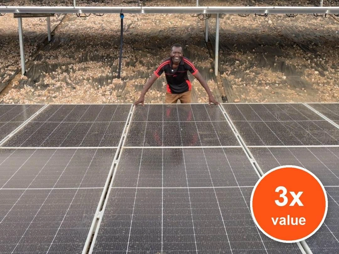 A smiling man in a black shirt stands behind solar panels with his hands resting on them. Badge: 3x value.