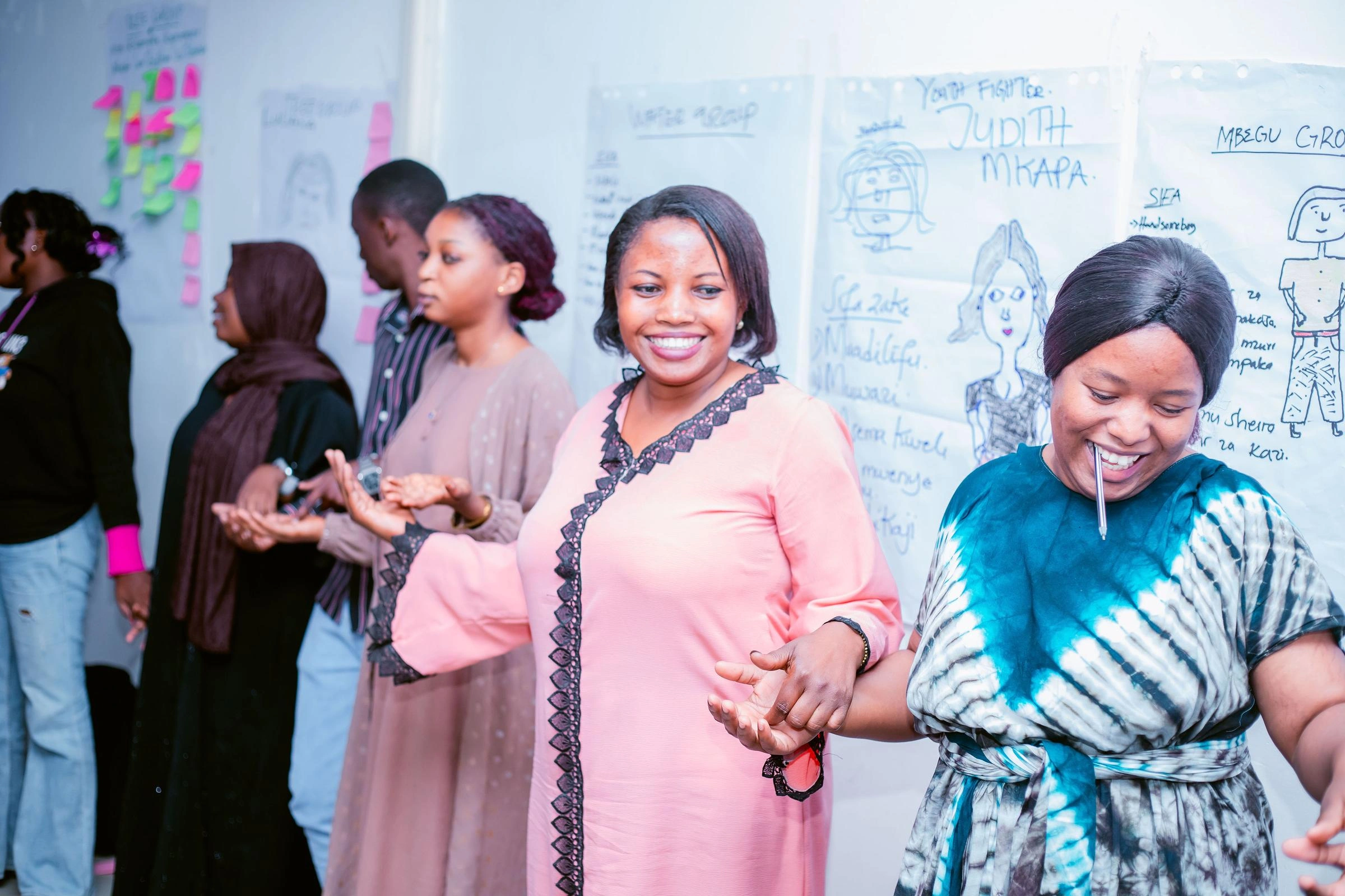 A group of women smile and hold hands